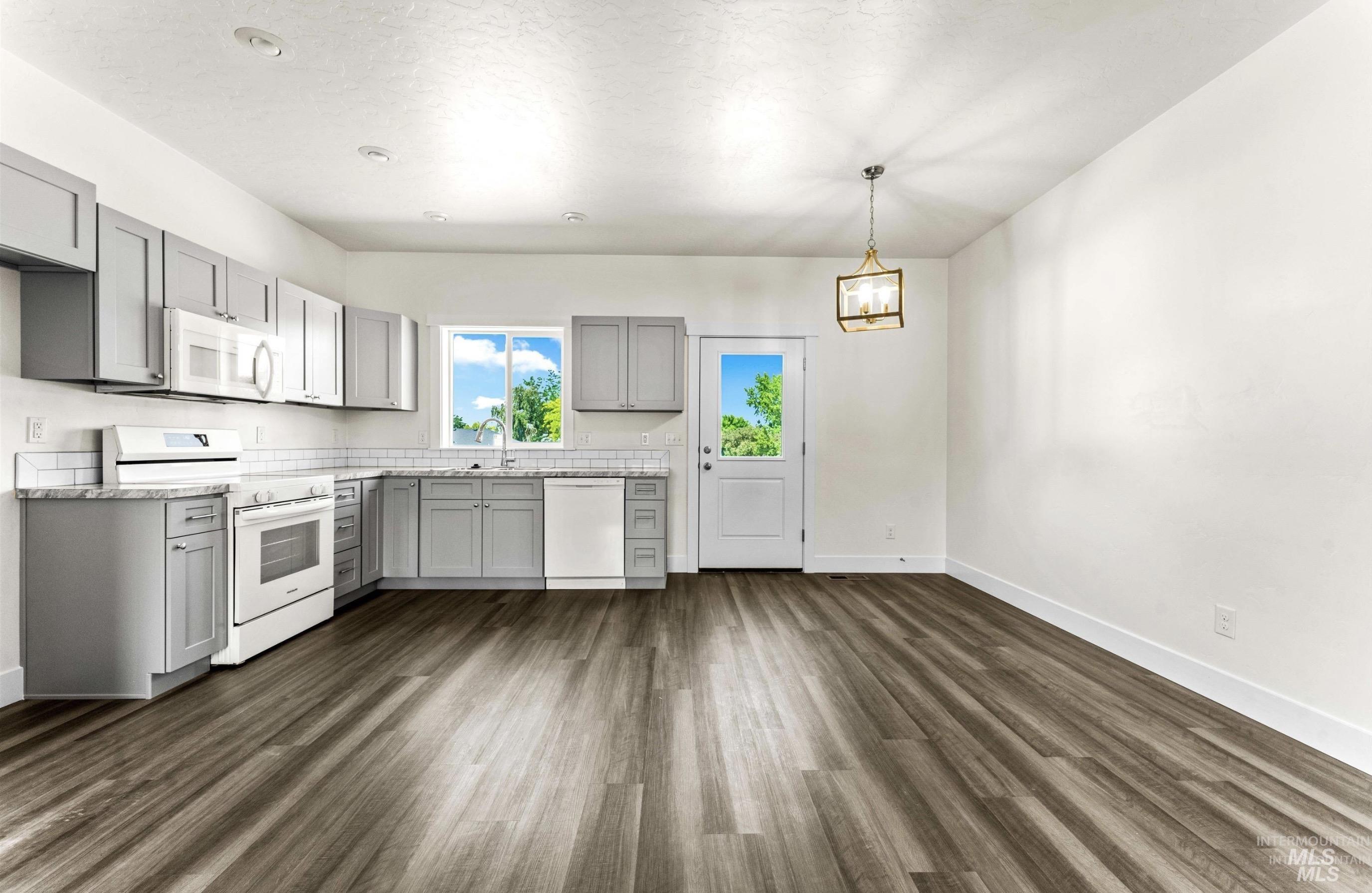 1771 Regency Way Emmett, ID 83617 - Photo 4 of 9 Kitchen featuring gray cabinets, white appliances, light countertops, and dark wood finished floors