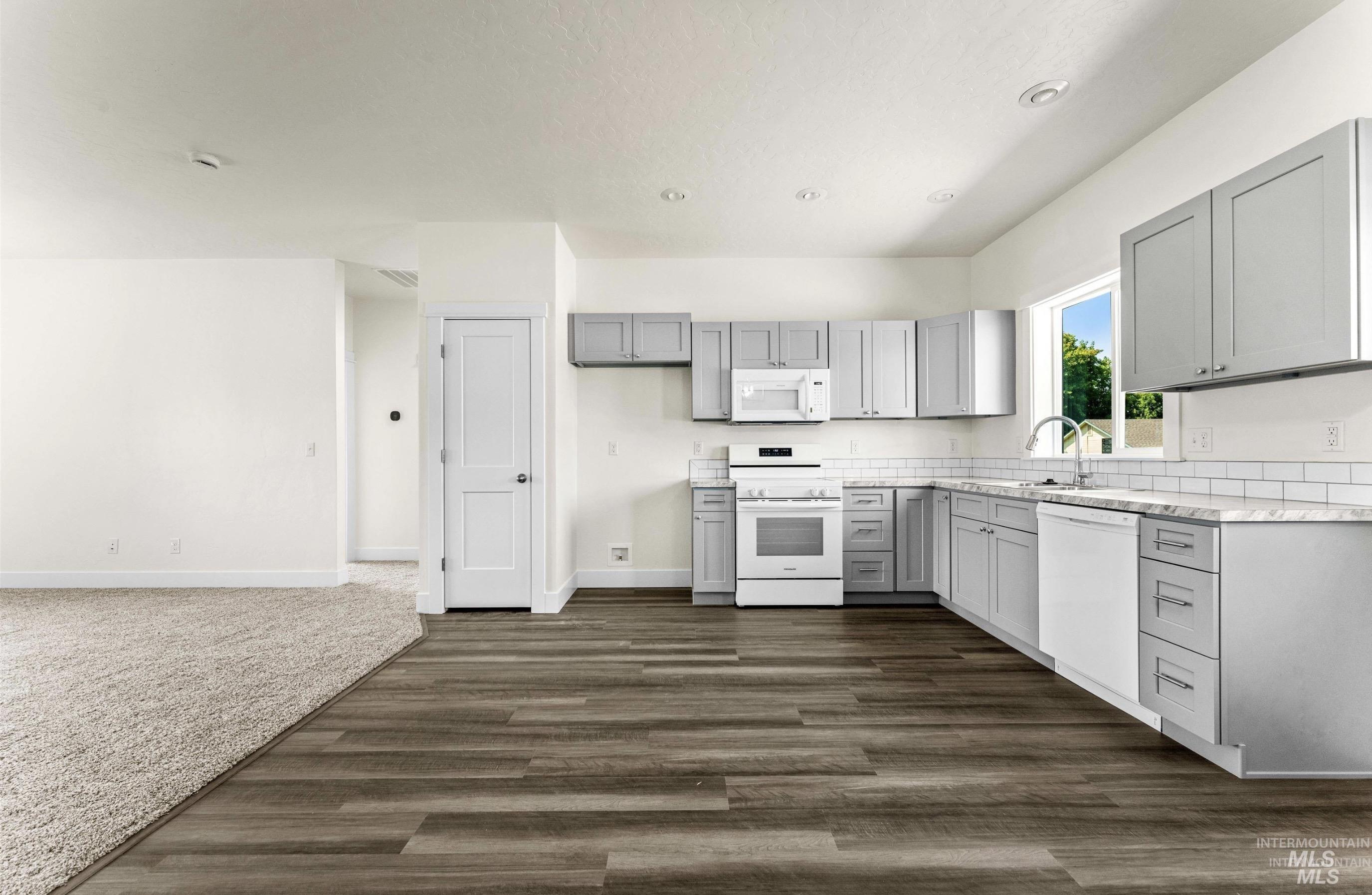 1771 Regency Way Emmett, ID 83617 - Photo 5 of 9 Kitchen featuring gray cabinetry, white appliances, dark wood-style floors, and recessed lighting
