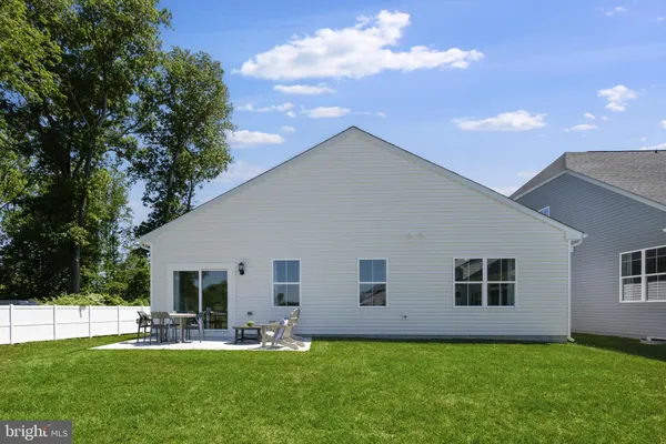 a backyard of a house with garden and outdoor seating