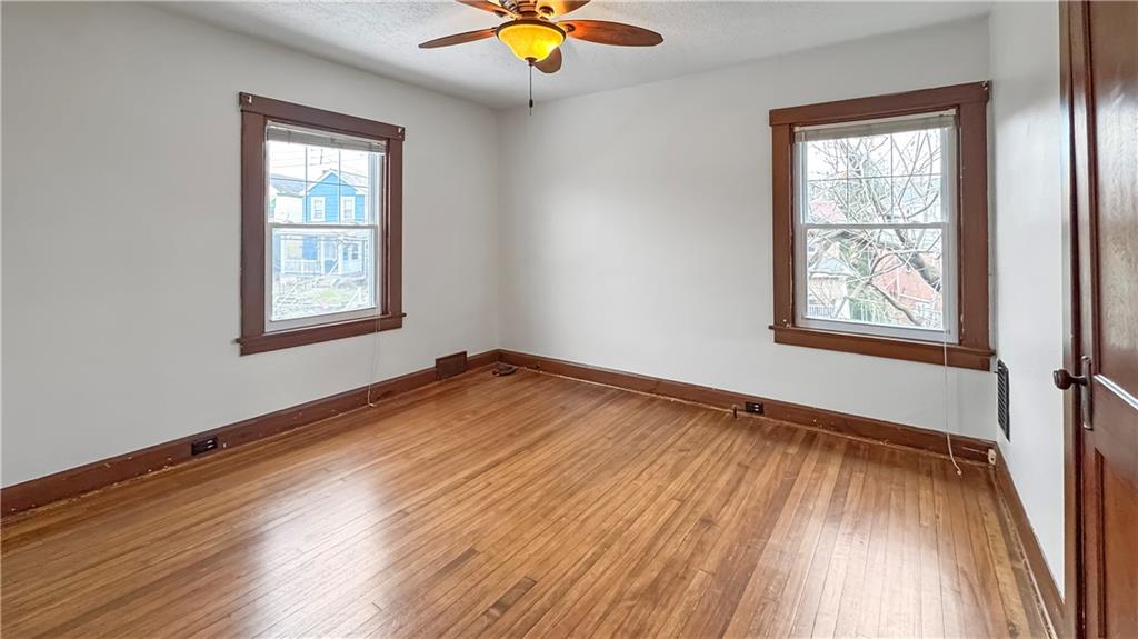 1601 Aurelius Avenue Pittsburgh, PA 15218 - Photo 23 of 30 an empty room with wooden floor and windows