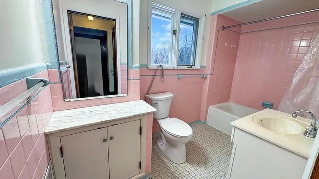 a bathroom with a granite countertop sink toilet mirror and a bathtub
