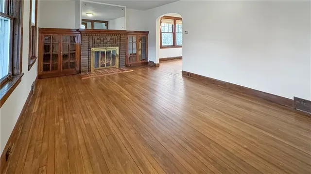 a big room with wooden floors and fireplace