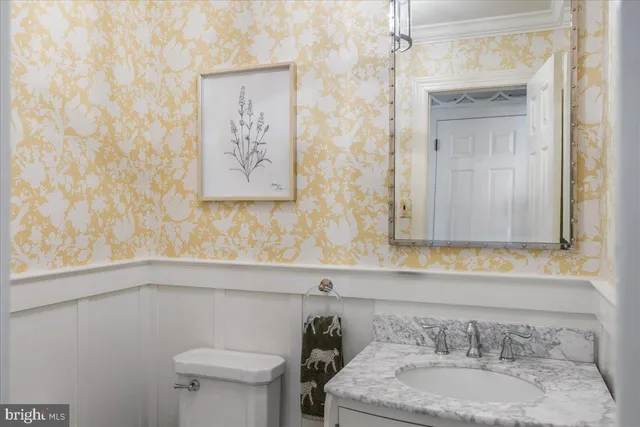 a large kitchen with granite countertop a large stove a sink and white cabinets with wooden floor