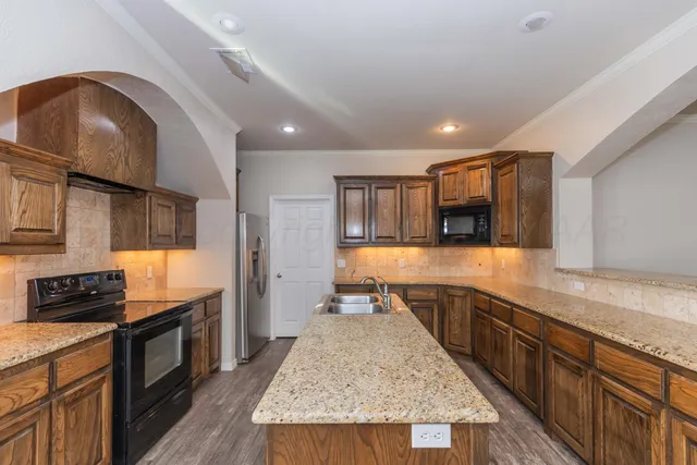 a kitchen with granite countertop stainless steel appliances and wooden cabinets