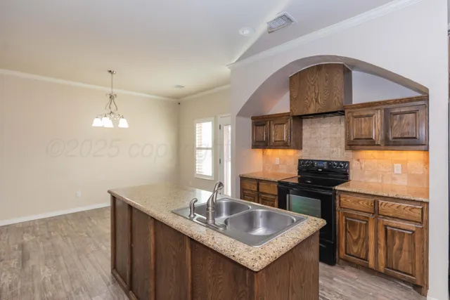a kitchen with granite countertop a sink stove and cabinets