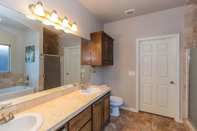 a bathroom with a sink vanity granite and toilet