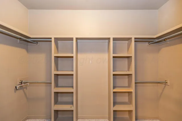 a view of walk in closet with empty racks