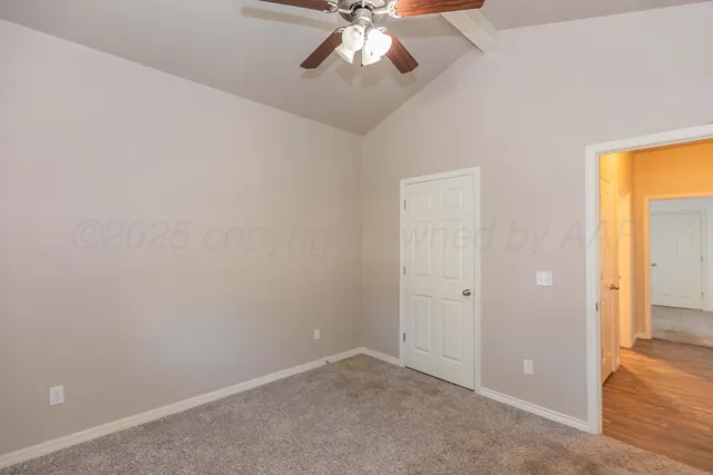 an empty room with closet and a chandelier fan
