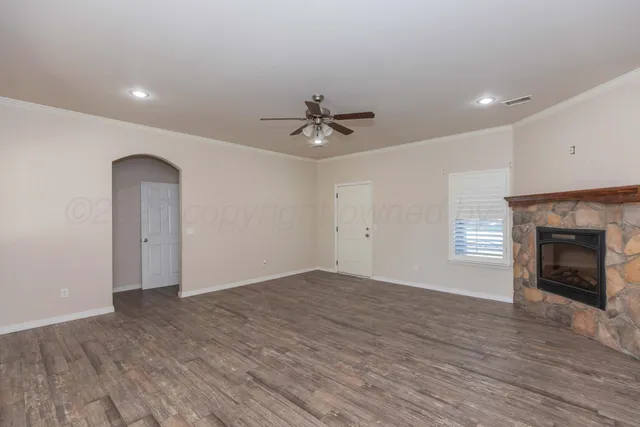 a view of an empty room with a fireplace and a window