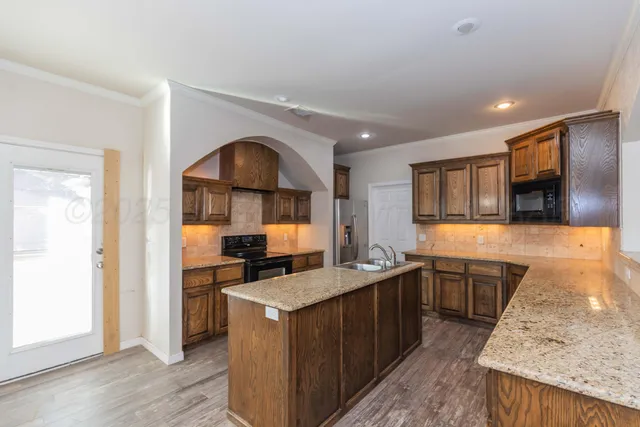 a kitchen with granite countertop a stove and a sink