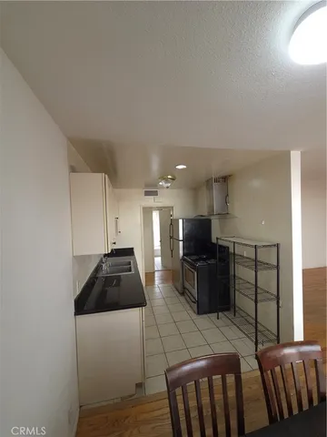 a kitchen with granite countertop a refrigerator and a stove top oven