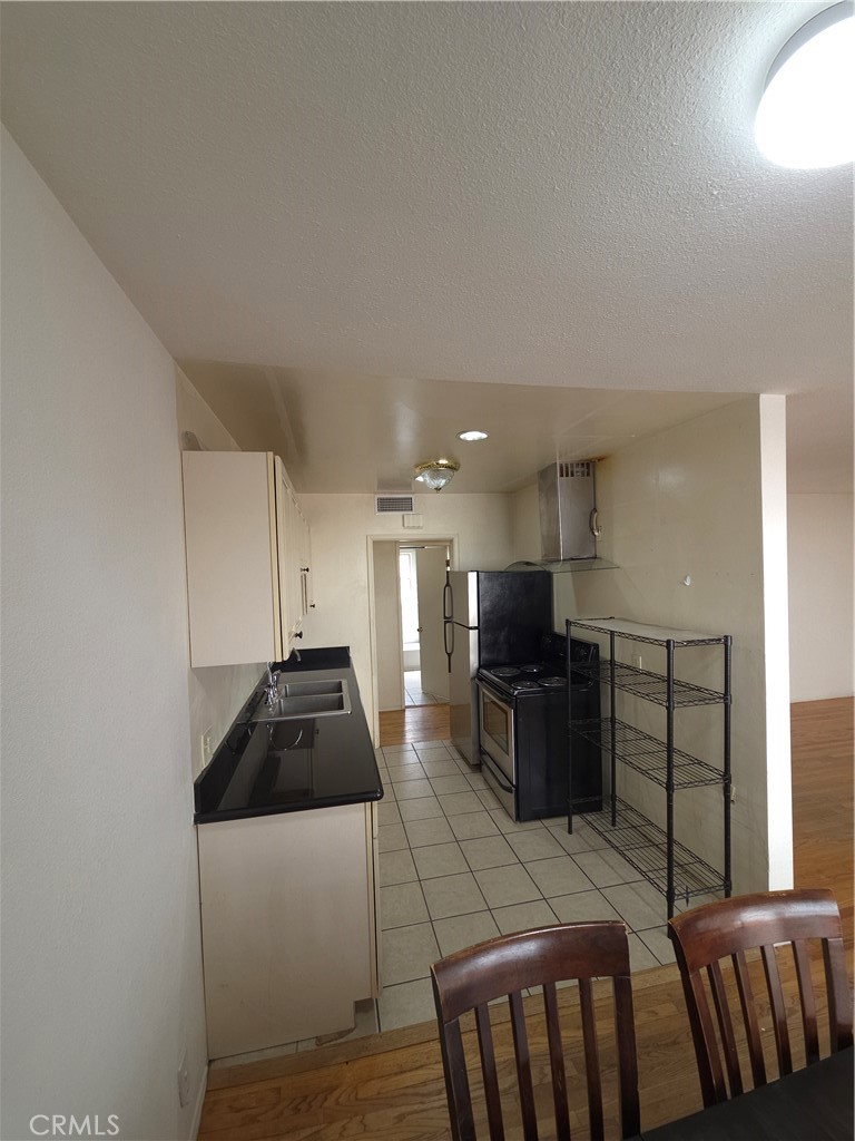 522 Cedar Avenue, Unit 3 Long Beach, CA 90802 - Photo 9 of 14 a kitchen with granite countertop a refrigerator and a stove top oven