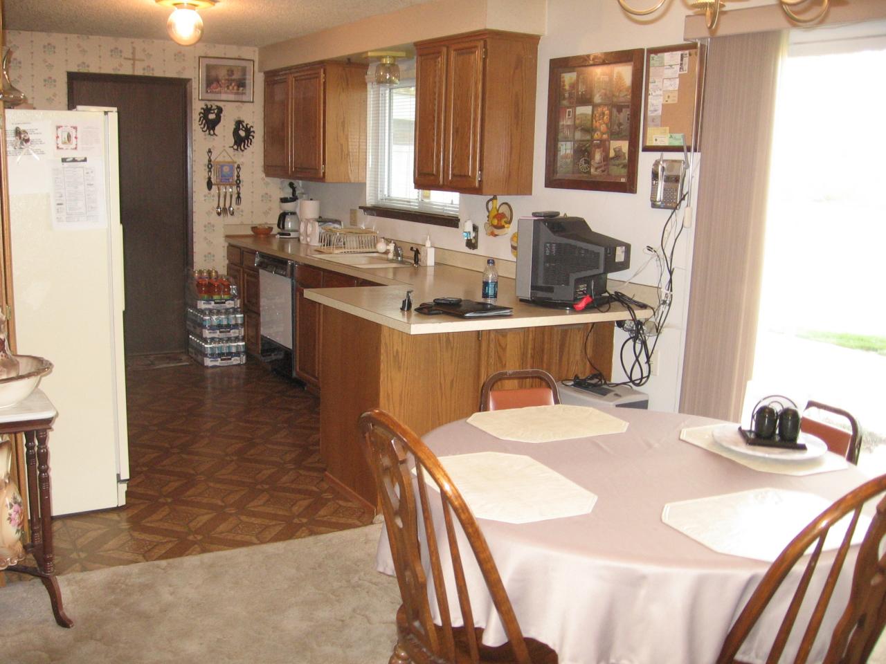 2411 Lateral 1 Road Wapato, WA 98951 - Photo 3 of 12 a room with a table chairs a refrigerator and a window