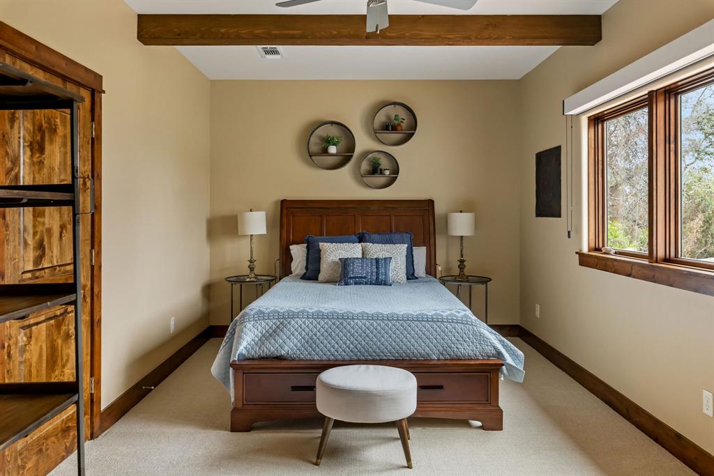 9930 Boat Club Road Fort Worth, TX 76179 - Photo 25 of 40 This upstairs bedroom with en suite in the main residence brings it own allure with beamed ceilings and natural lighting.