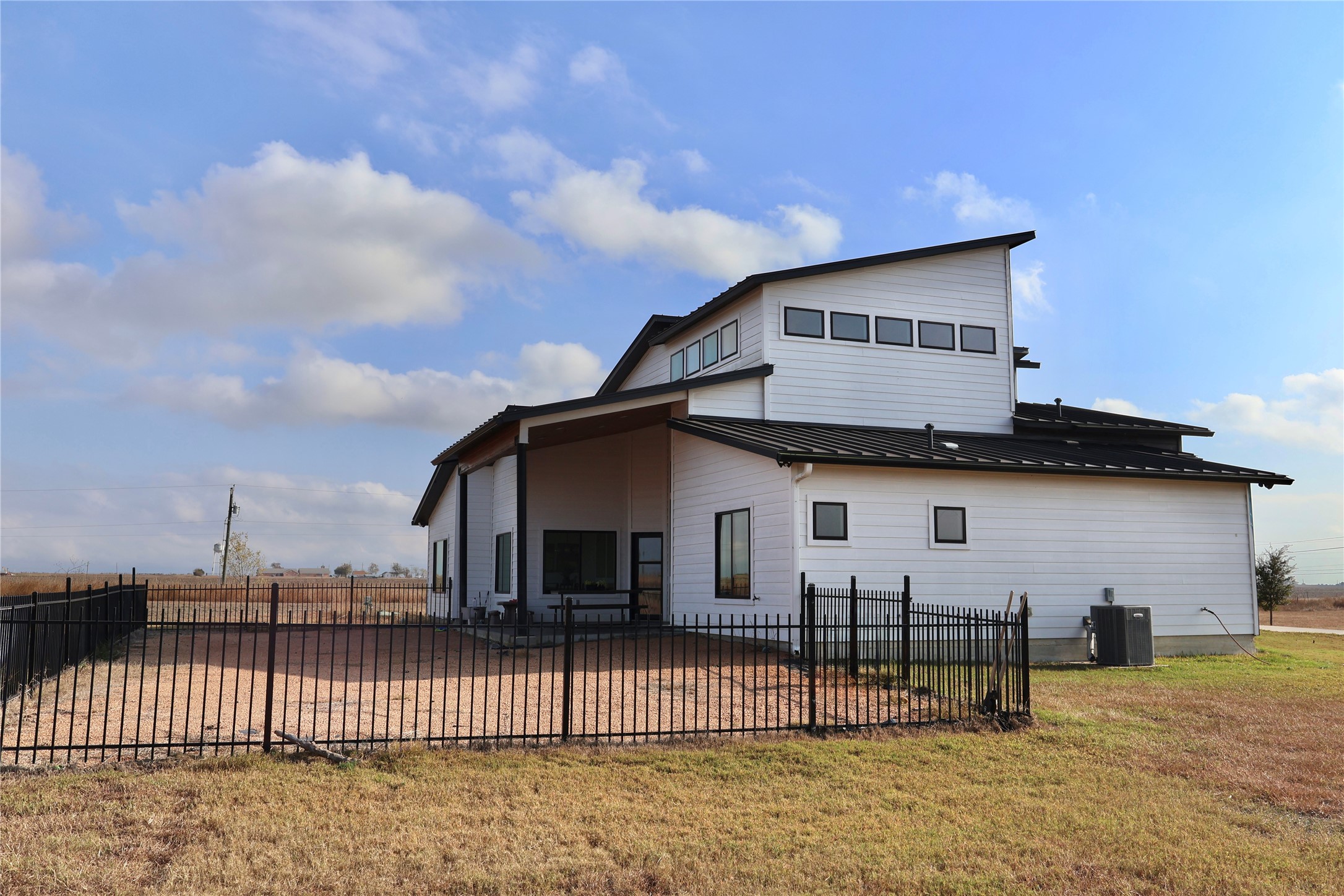 17216 Lund - Carlson Road Elgin, TX 78621 - Photo 14 of 17 Rear view of house with a patio area, a metal roof, a fenced backyard, and a standing seam roof