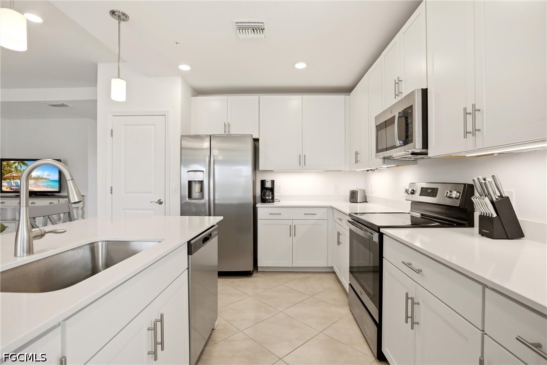 3751 Pebblebrook Ridge Court, Unit 101 Fort Myers, FL 33905 - Photo 6 of 48 a kitchen with a sink white cabinets and stainless steel appliances