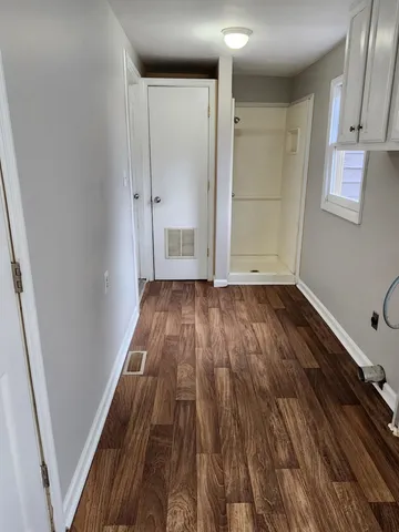 a view of a room with wooden floor and white walls