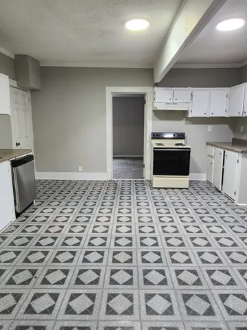 a kitchen with granite countertop a stove a sink and a microwave