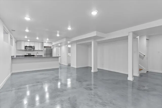 a view of kitchen with refrigerator and white cabinets