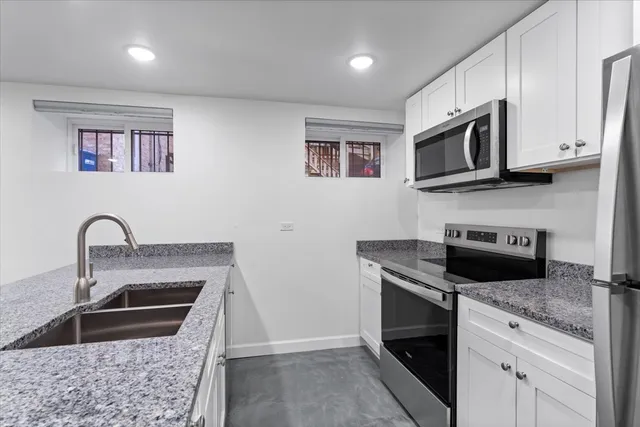 a kitchen with stainless steel appliances granite countertop a stove microwave and sink