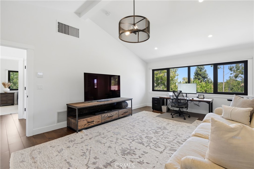24884 Jim Bridger Road Hidden Hills, CA 91302 - Photo 24 of 31 a living room with furniture a flat screen tv and a large window
