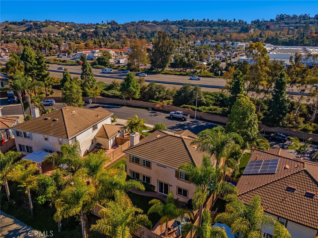 4330 Forest Ranch Way Oceanside, CA 92057 - Photo 43 of 51 This aerial view expands outward to reveal the backyard in full context, showing neighboring homes on either side and emphasizing the sense of community while still maintaining a comfortable level of privacy.