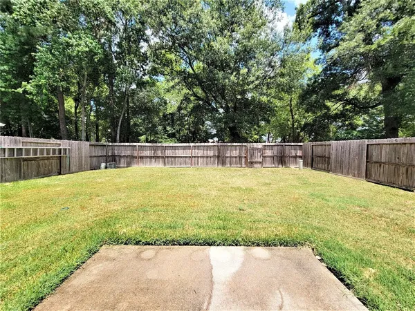 a view of a swimming pool with a lawn chairs and a large tree