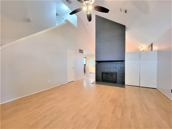 a view of a livingroom with a fireplace and chandelier fan