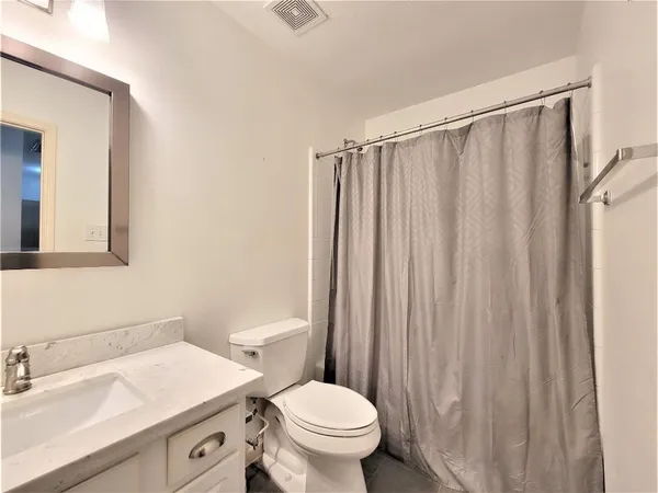 a bathroom with a sink a toilet a mirror and shower curtain