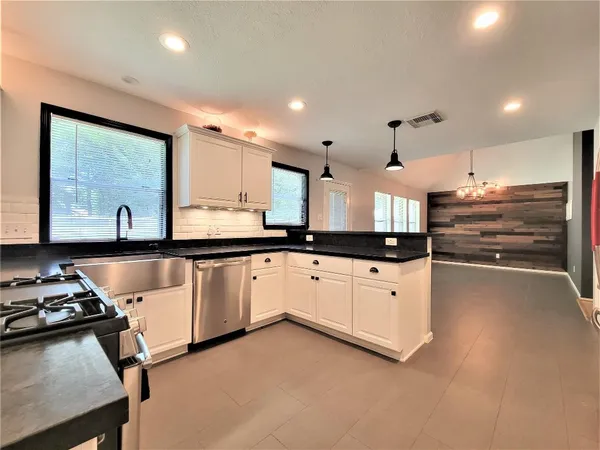 a kitchen with stainless steel appliances granite countertop a stove a sink and a refrigerator