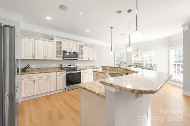 a large kitchen with kitchen island a stove a sink a center island and windows