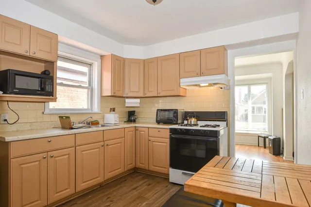 a kitchen with a sink stove top oven and cabinets