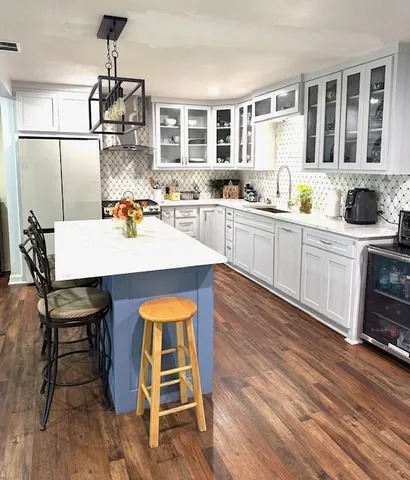 a kitchen with a dining table chairs and white appliances