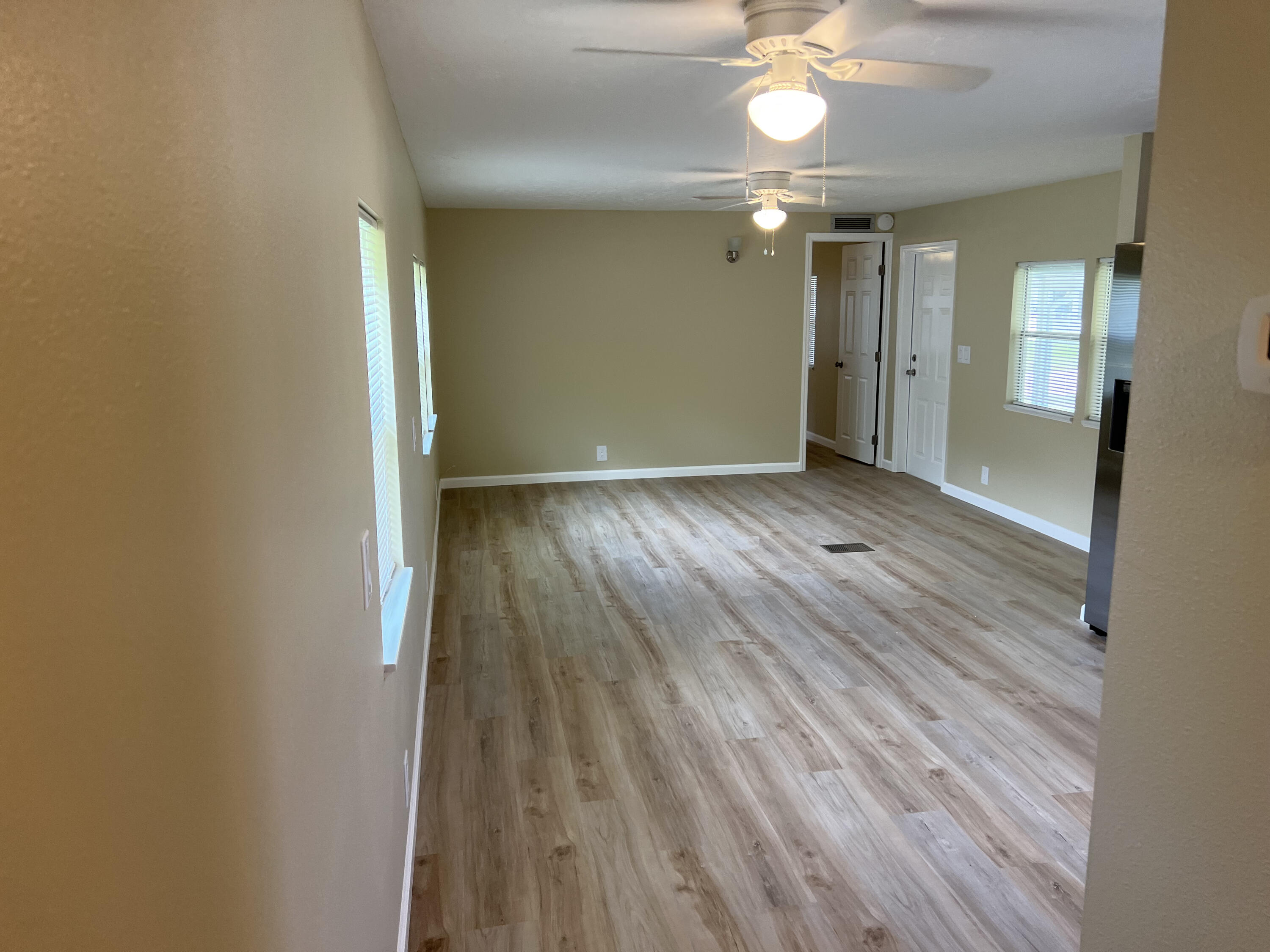 1065 Moonlight Court Palm Bay, FL 32907 - Photo 2 of 11 wooden floor in an empty room with a mirror