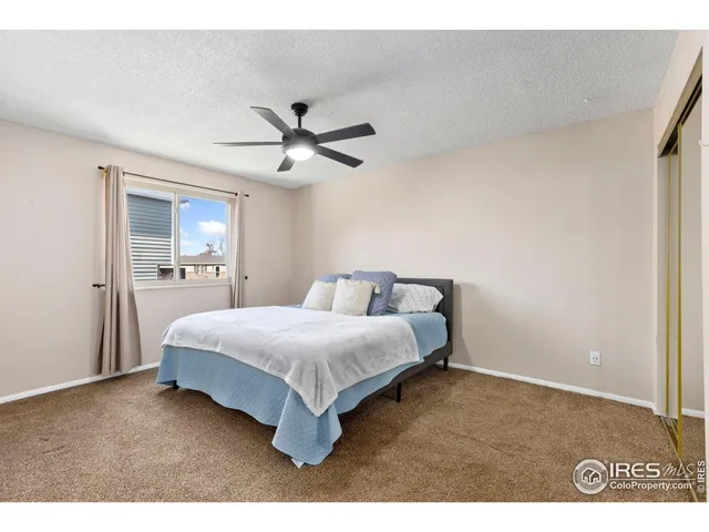 a spacious bedroom with a bed and a chandelier