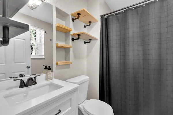 a bathroom with a sink toilet and shower
