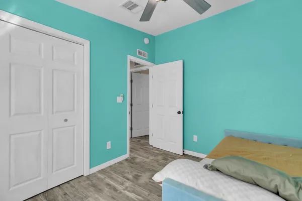a bedroom with a bed and a chandelier fan