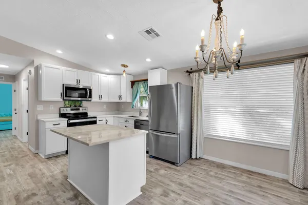 a kitchen with stainless steel appliances granite countertop a refrigerator a stove a sink and a refrigerator