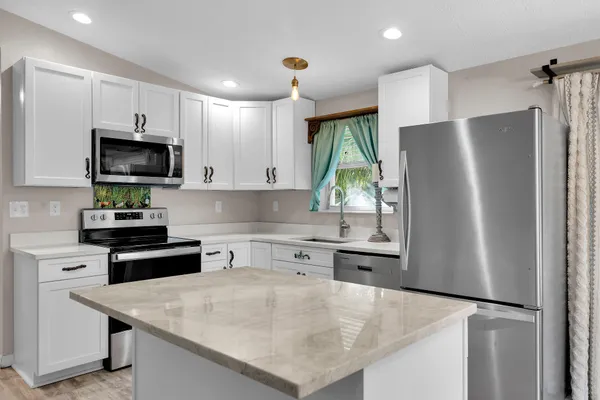 a kitchen with stainless steel appliances a refrigerator sink and microwave