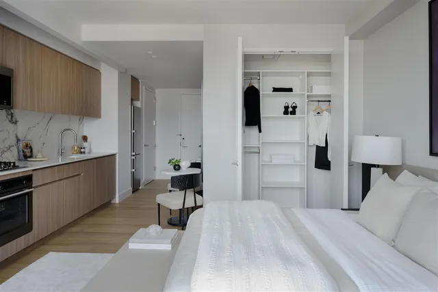 a bedroom with a bed and a view of kitchen