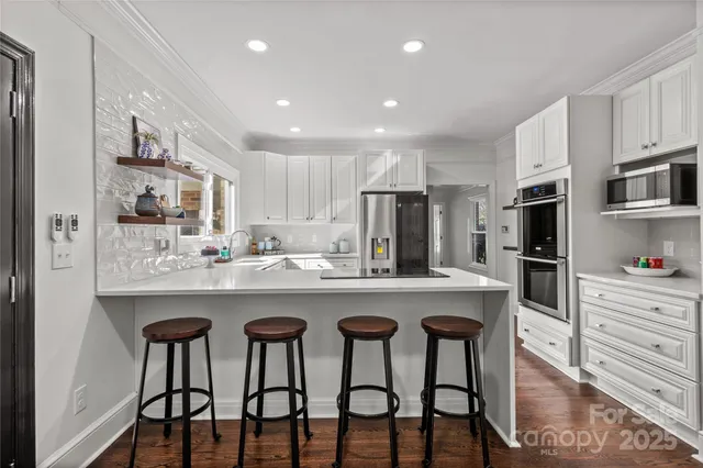 a kitchen with white cabinets and stainless steel appliances