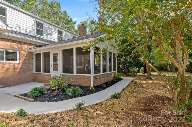 a view of a house with a yard and potted plants