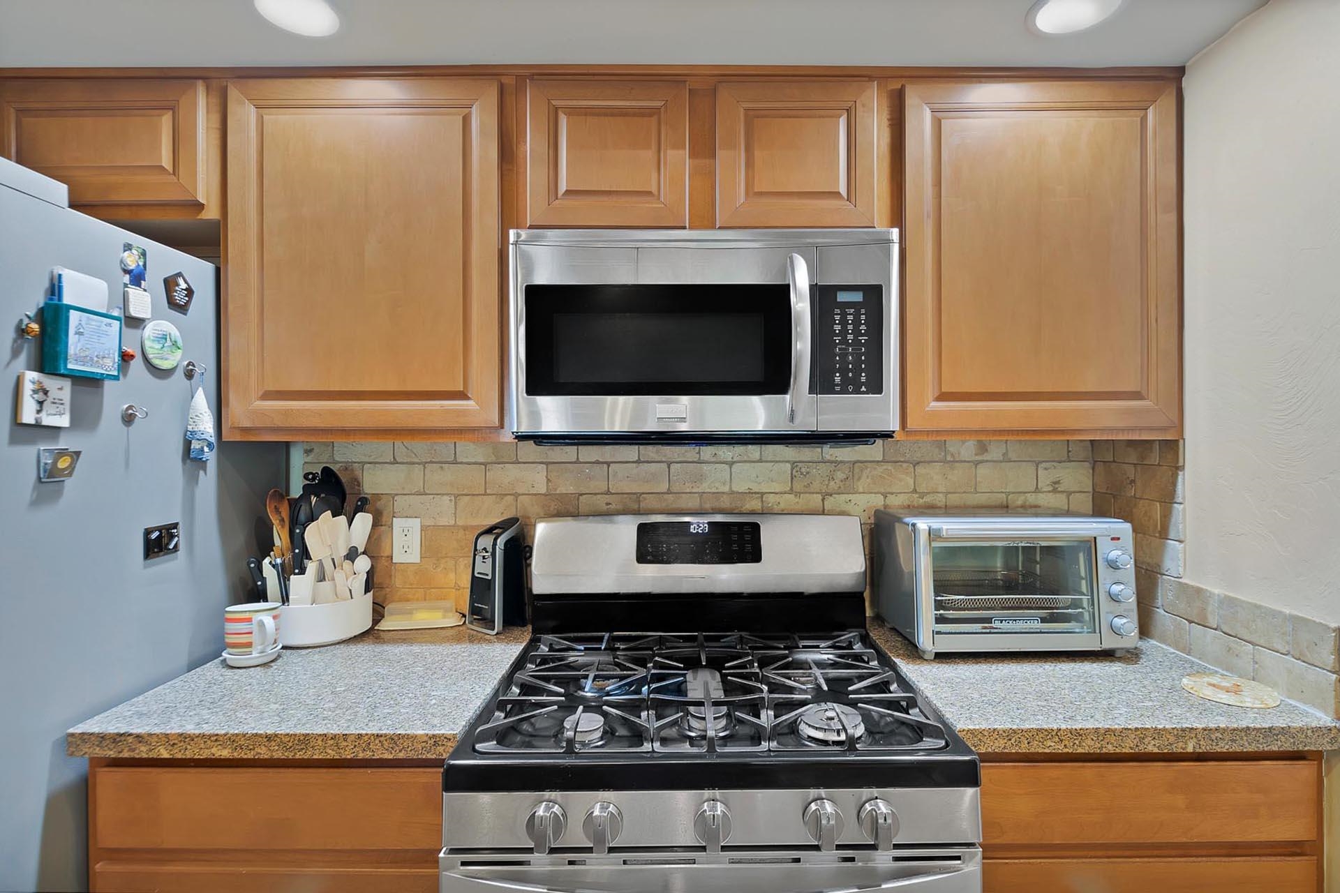 247 Mason Ridge Drive Grand Junction, CO 81503 - Photo 22 of 40 a kitchen with granite countertop stainless steel appliances stove top oven and cabinets