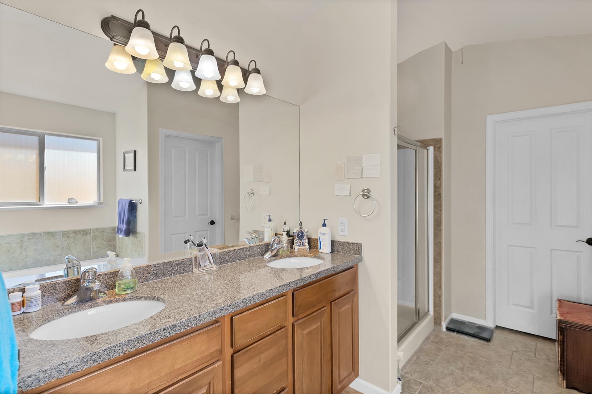 247 Mason Ridge Drive Grand Junction, CO 81503 - Photo 26 of 40 a bathroom with double vanity sinks a vanity a lamp and a mirror