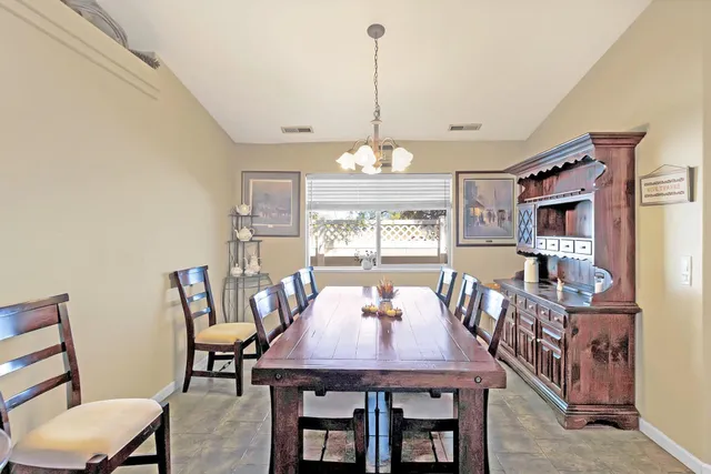 a bedroom with a bed a mirror and lamp on dresser