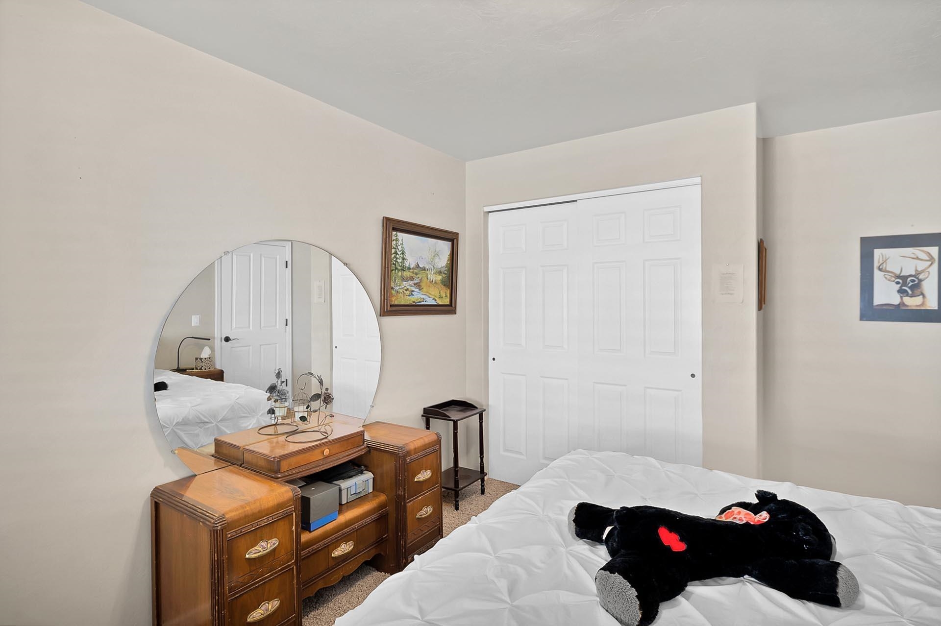 247 Mason Ridge Drive Grand Junction, CO 81503 - Photo 32 of 40 a bedroom with a bed a mirror and lamp on dresser