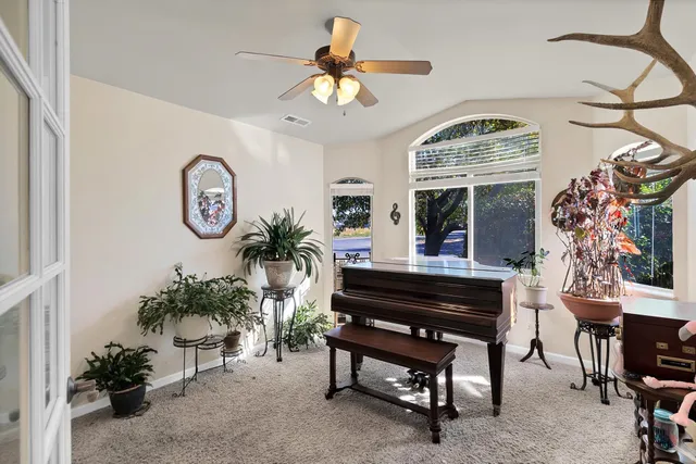 a view of a livingroom with furniture window and a ceiling fan