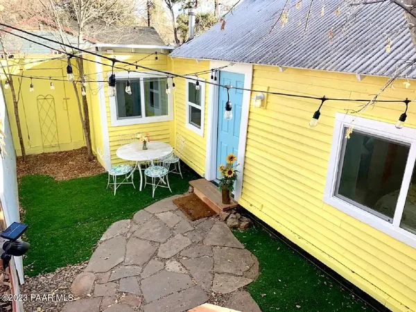 a view of a small house with backyard