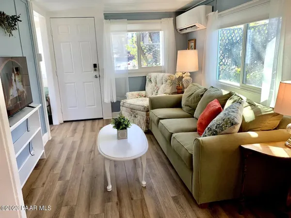 a living room with furniture and a wooden floor