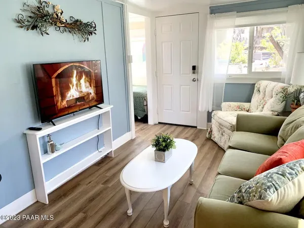 a living room with furniture a flat screen tv and a window